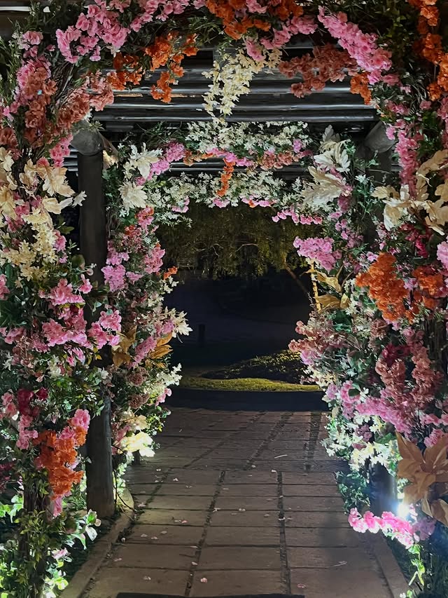 Túnel de arcos de flores conduzindo ao lago